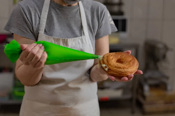 Şekerlemeci donutları vanilyalı kremayla doldurur.