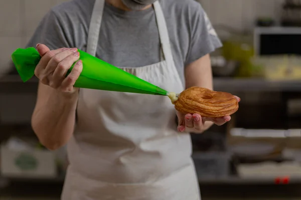 Şekerlemeci donutları vanilyalı kremayla doldurur.