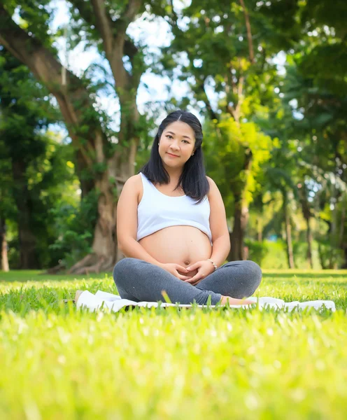 Beautiful pregnant asian woman relaxing in the park — Stock Photo, Image