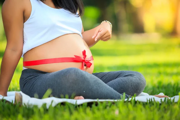 Beautiful pregnant asian woman reading the book in the park — Stock Photo, Image