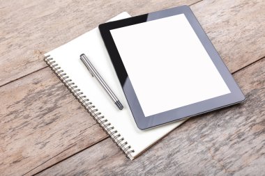 Tablet ve ahşap masaüstündeki bir not defteri