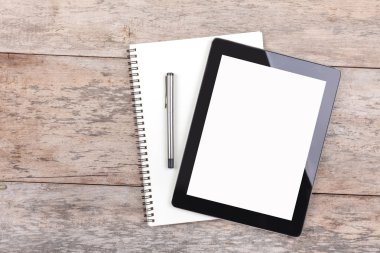 Tablet ve ahşap masaüstündeki bir not defteri