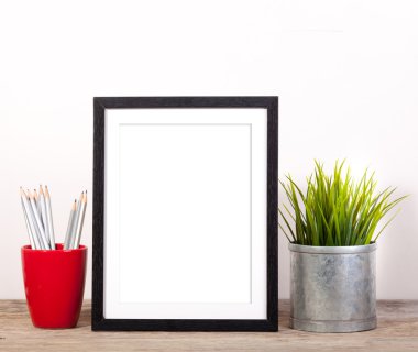 resim çerçevesi office öğeleri ve ahşap masa üzerinde pot planr