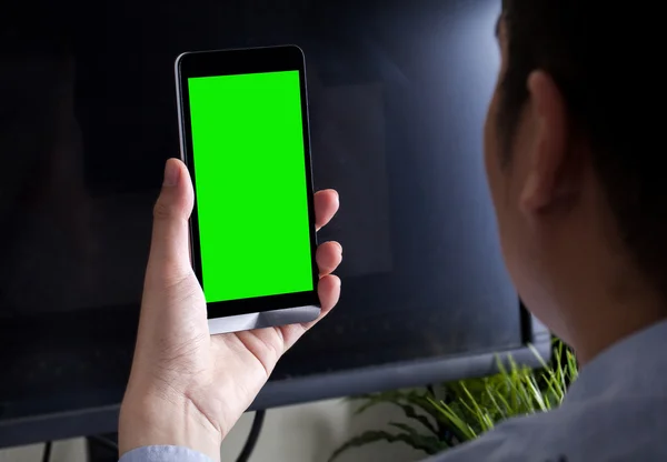 Hombre sosteniendo el teléfono sobre una mesa de espacio de trabajo —  Fotos de Stock