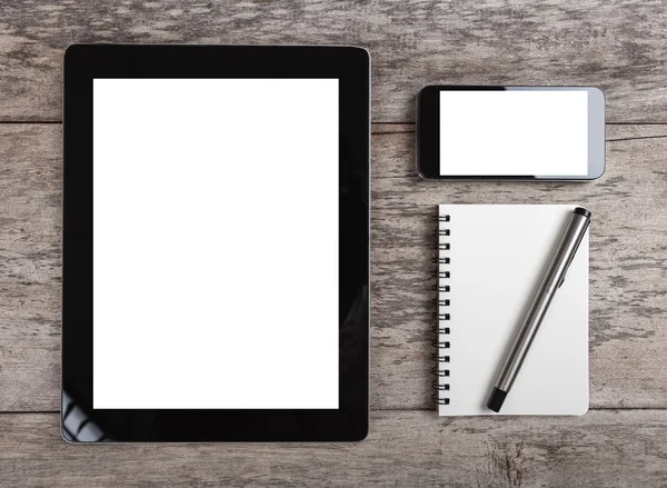 Tablet vazio e telefone inteligente com papel de nota na mesa de madeira — Fotografia de Stock