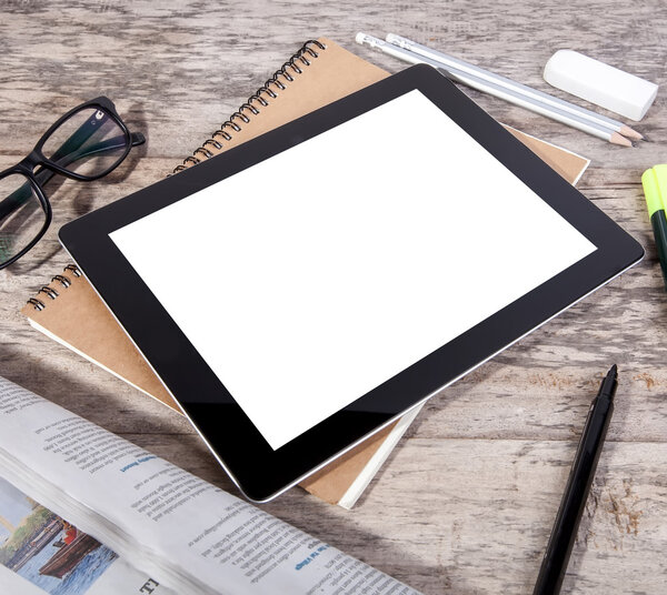 Messy table with tablet blank screen