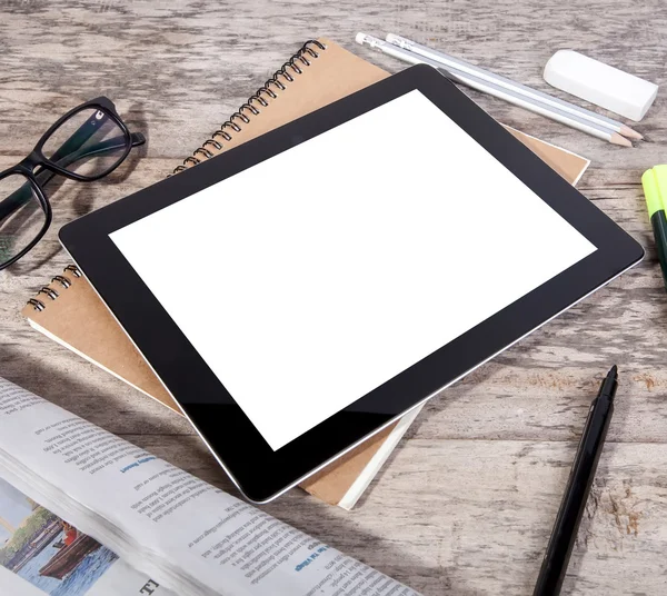 Mesa desordenada con pantalla en blanco de tableta — Foto de Stock