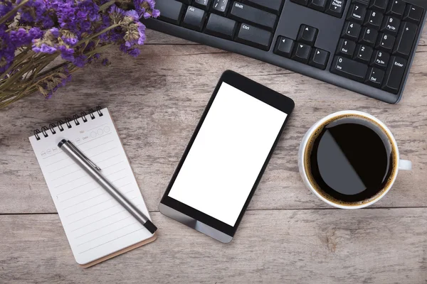 Arbetar bord med smart telefon Obs papper penna blommor och kopp — Stockfoto