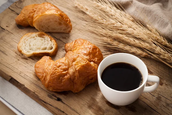 Tasty croissant and coffee still life rustic — Stock Photo, Image