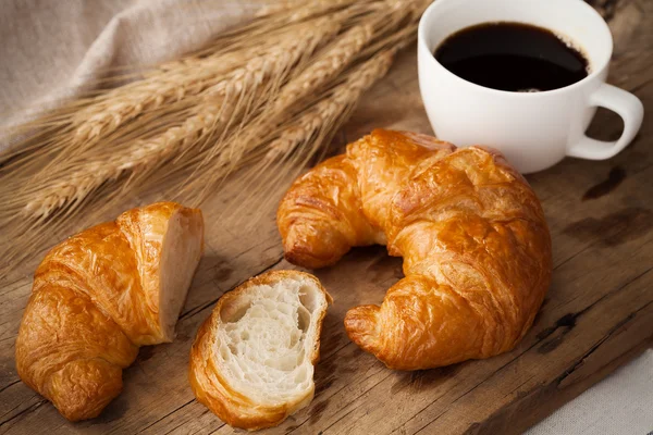 Tasty croissant and coffee still life rustic — Stock Photo, Image