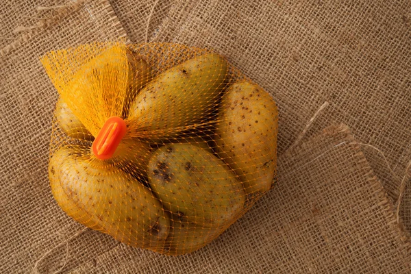 Aardappel stilleven op zak achtergrond plat leggen — Stockfoto