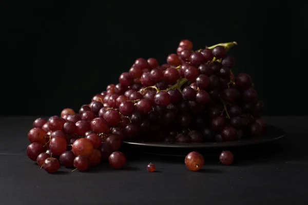 Uva viola natura morta su sfondo nero — Foto Stock