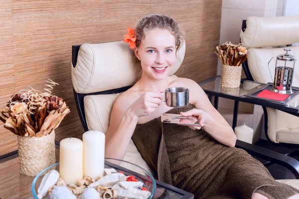 Красива жінка в спа-салоні розслабляється з чашкою чаю в кімнаті відпочинку. портрет краси — стокове фото