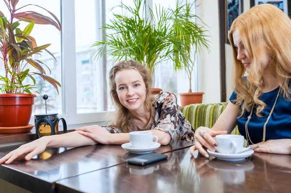 Dwa piękne młode kobiety przy tabletka komputera w kawiarni poza — Zdjęcie stockowe