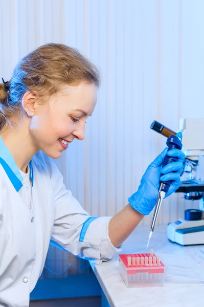 Vrouw wetenschapper scheikundige met een pipet in hand maakt de analyse in het moderne laboratorium — Stockfoto