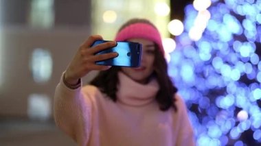 Noel 'de çelenklerle ve bayram ışıklarıyla gülümseyen kadın