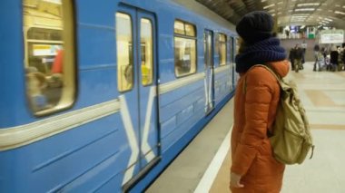 RUSSIA, NOVOSIBIRSK - 03 Mar 2020: metro istasyonunda tren bekleyen kadın. Metro geliyor.