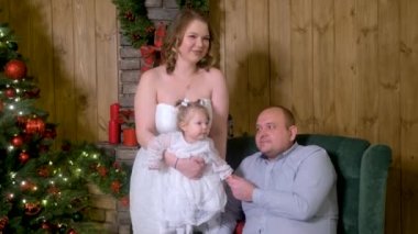 Üç kişilik Noel ailesi. Mutlu ebeveynler ve küçük komik bebek