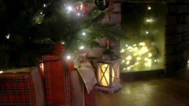 Arka planda ağaç hediyeleri ve şömineli Noel sahnesi