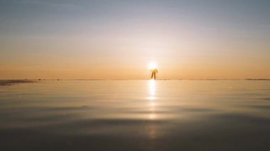 Baykal Gölü 'nde gün doğumunda ya da kışın günbatımında buz patencisi. Siluet