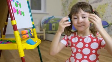 çocuk evde harf ve numara öğrenmek için mıknatıs tahtası kullanıyor