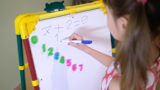 Menina usando placa ímã para aprender letras e números em casa — Vídeo de Stock