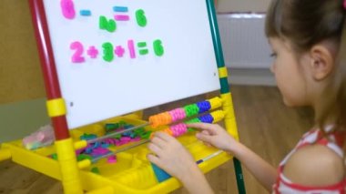 Çocuk abaküs kullanarak evde sayı ve hesap öğreniyor.