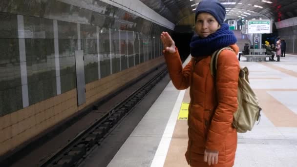 Αστεία γυναίκα διασκεδάζει ενώ περιμένει το μετρό. δείχνοντας ειδώλια με τα χέρια του — Αρχείο Βίντεο
