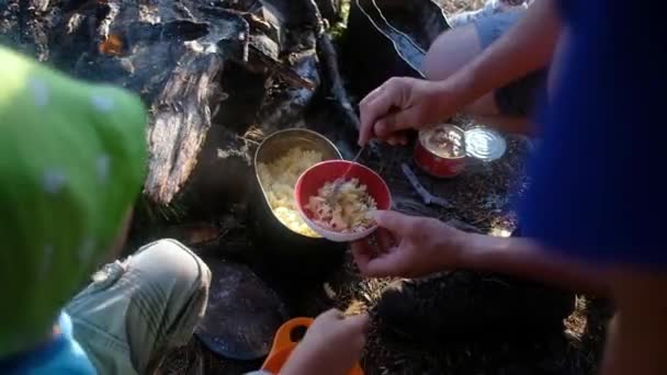 Família acampando fazendo comida. Pai dá comida para crianças em pratos — Vídeo de Stock