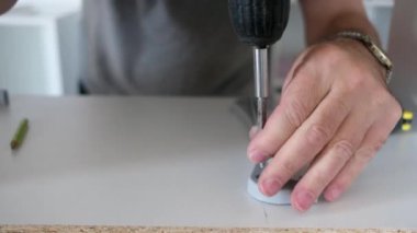 Yaşlı adam mobilya sondajı yapıyor. Evdeki yenileme işlerinde sondaj yapıyor.