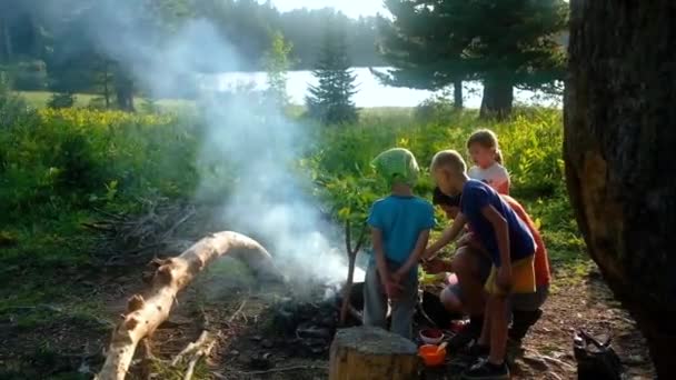 Camping familiar. Padre y tres niños cocinando en fogata — Vídeos de Stock