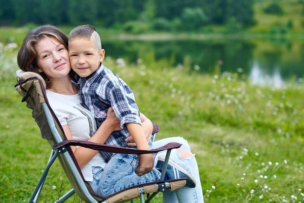 母と息子は椅子に座って湖の近くの自然の中でリラックスしています 夏の野外活動 国立公園での冒険旅行 レジャー休暇リラックス — ストック写真