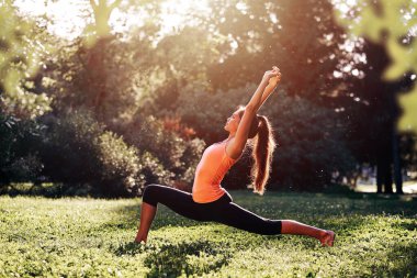 Yoga. Yoga yapan, dans eden ya da parkta esneme hareketleri yapan genç bir kadın. Sağlık yaşam tarzı kavramı.