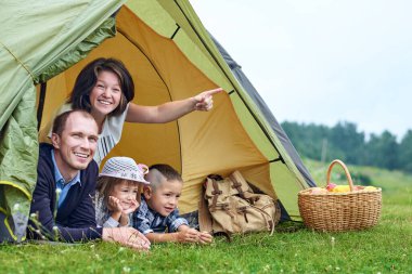 Aile ve iki çocuk kamp çadırında. Mutlu anne, baba, oğul ve kız yaz tatili.