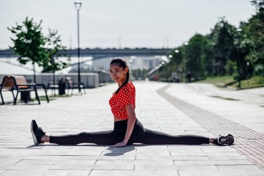 Esneyen jimnastikçi kadın kırışıyor, şehirde sicim yapıyor..
