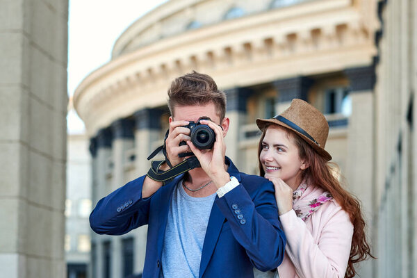 Happy love couple of tourists taking photo on excursion or city tour. Traveling together