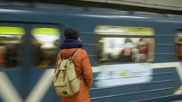 RUSKO, NOVOSIBIRSK - 03. 3. 2020: žena na nástupišti čeká na nástupišti ve stanici metra. Metro přijíždí — Stock video