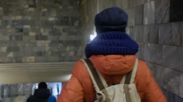 RUSSIA, NOVOSIBIRSK - Mar 03, 2020: Kamera merdivenlerden aşağı inen genç turist kadını sırt çantasıyla metroya doğru takip ediyor — Stok video