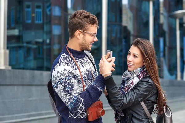 スマートフォンで幸せなカップル 一緒に屋外に立って一緒に携帯電話を見て幸せな若い愛情のカップル — ストック写真
