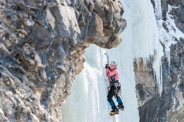 Woman mountaineer climbs on vertical icefall — Stock Photo, Image