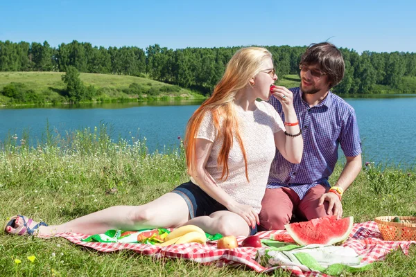 Menino e menina em um piquenique perto do lago — Fotografia de Stock