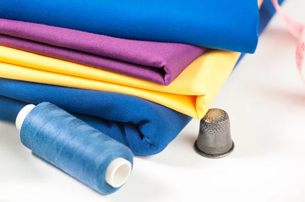 Kolorowe tkaniny, nici, gilzy i centymetr — Zdjęcie stockowe