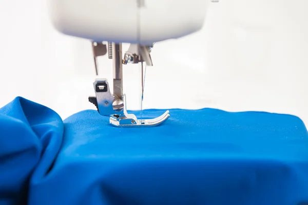 Máquina de costura e tecido drapeado sobre um fundo branco — Fotografia de Stock