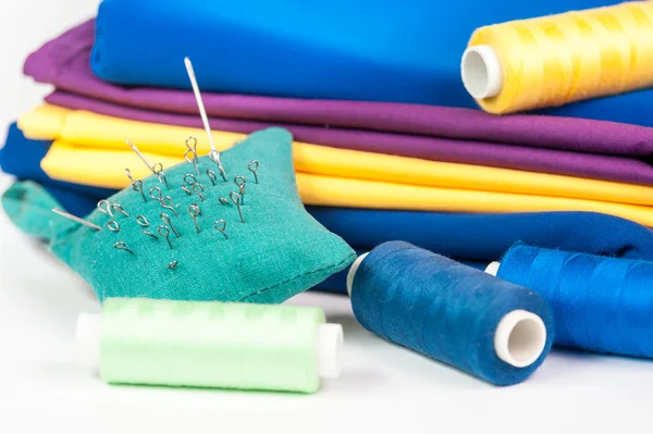 Kolorowe tkaniny, nici i igły — Zdjęcie stockowe