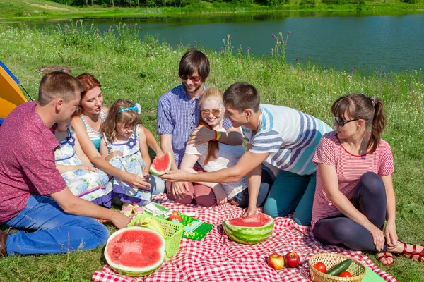 Göl kenarında piknik ve karpuz zevk mutlu bir aile portresi açık grubu — Stok fotoğraf