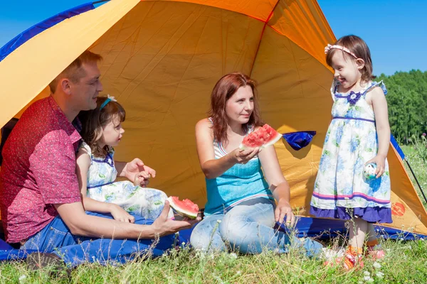 Retrato de grupo al aire libre de compañía feliz teniendo picnic cerca de la tienda en el parque y disfrutando de la sandía — Foto de Stock