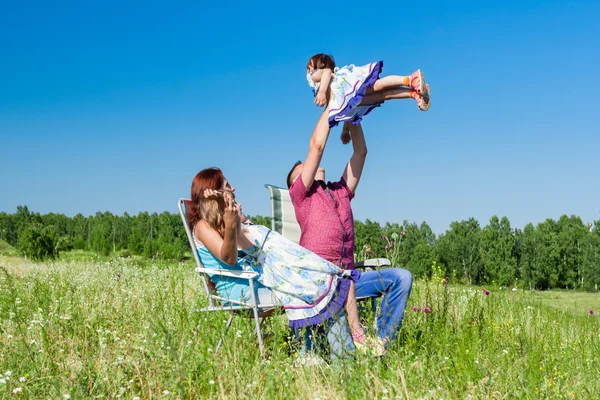 Retrato al aire libre de una familia feliz. padre recogió al niño en sus brazos — Foto de Stock