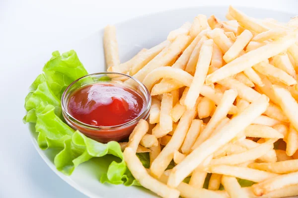 Papas fritas con salsa de tomate y lechuga sobre un fondo blanco —  Fotos de Stock