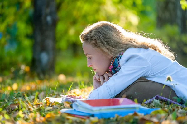 Étudiante réfléchie lit dans le parc d'automne — Photo