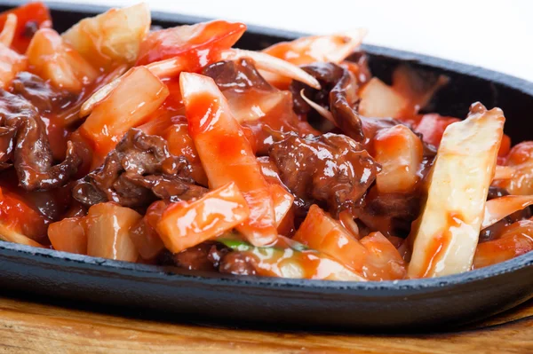Мясо и картофель жаркое в томатном соусе в кастрюле на белом фоне — стоковое фото